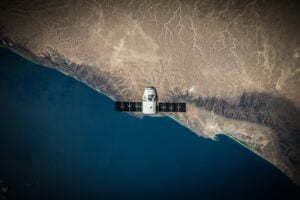Un satellite spatial en vol stationnaire au-dessus de la côte