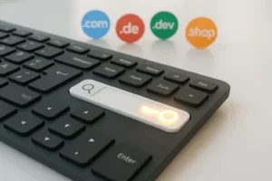 Clavier avec barre de recherche de domaine et différentes extensions de domaine sous forme d'icônes dans une lumière moderne